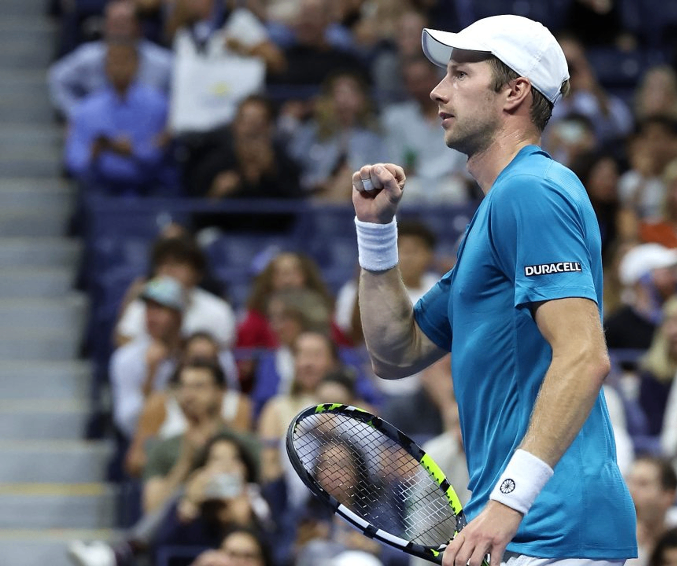 Tennis player celebrating with a fist pump wearing a Duracell patch