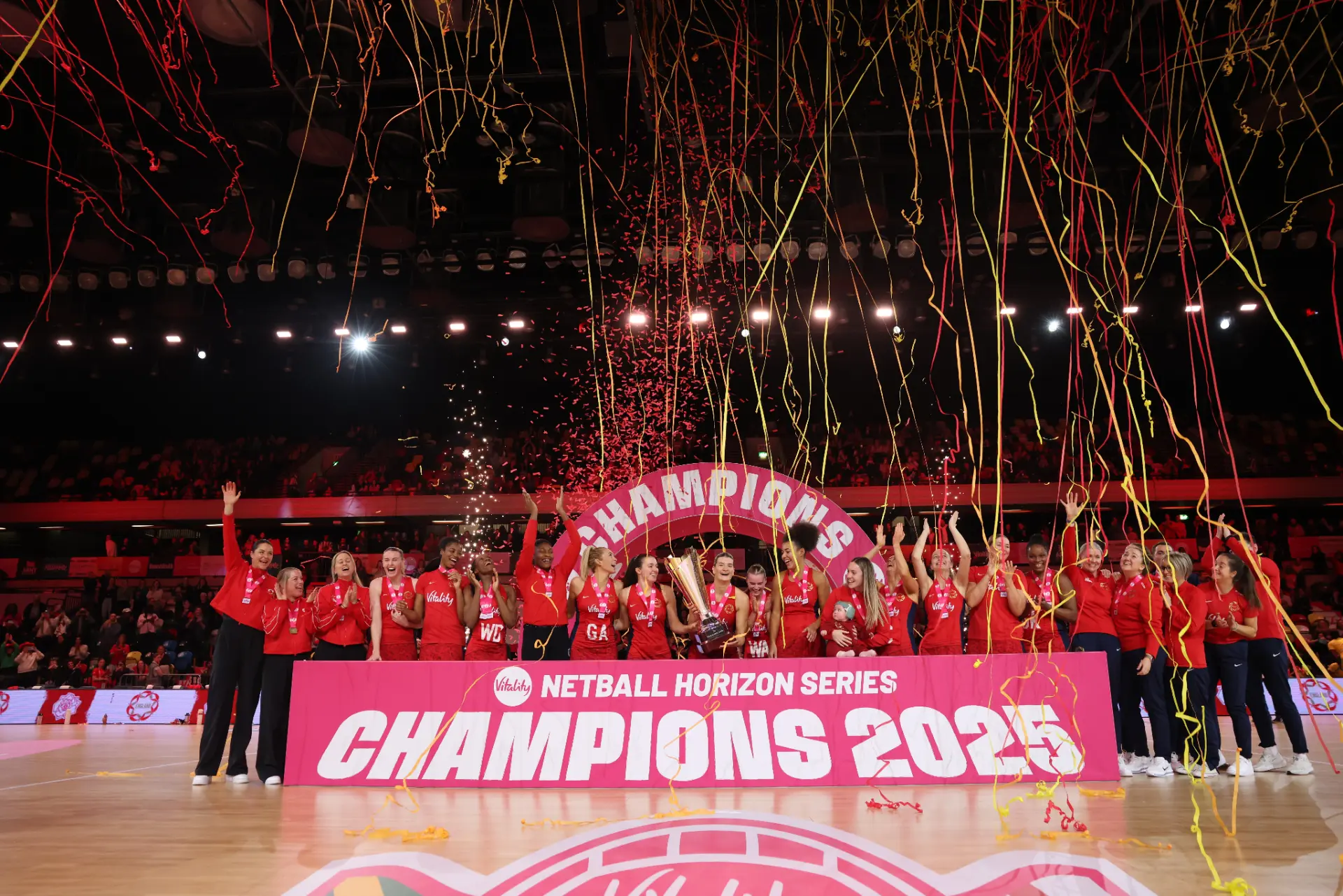 Elite netball match in a packed arena under bright lights